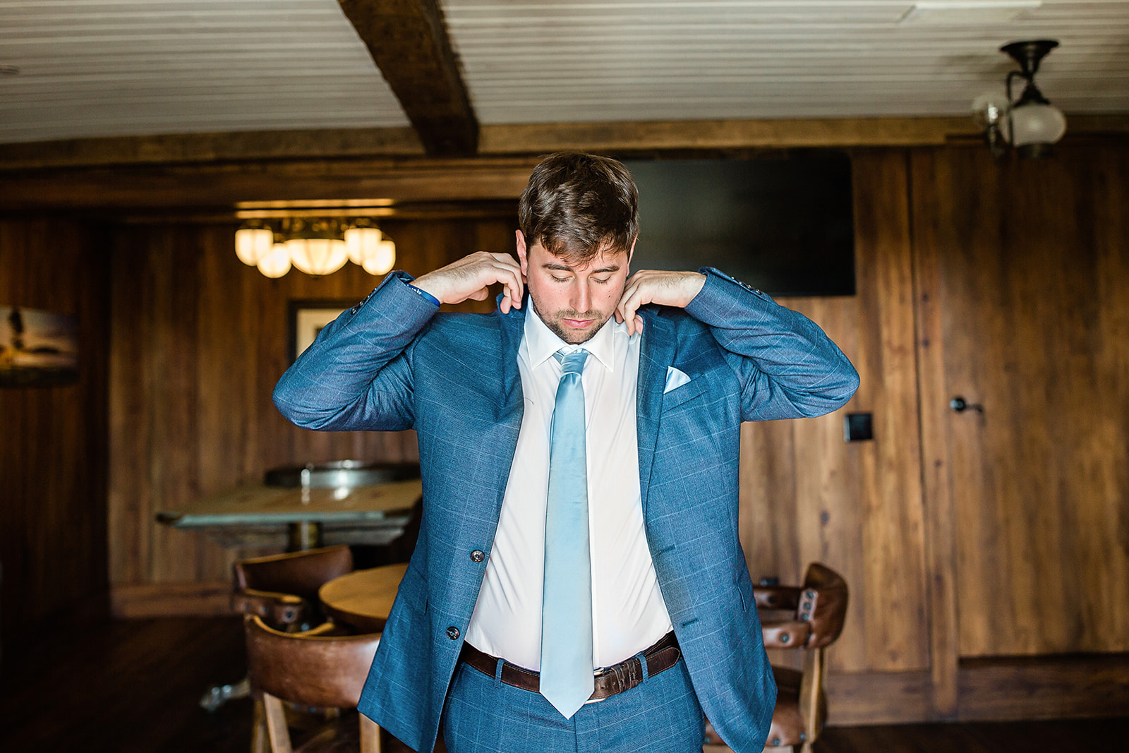 Groom getting his coat on and adjusting it at Big Cedar, Branson by Tatyana Zadorin Photography