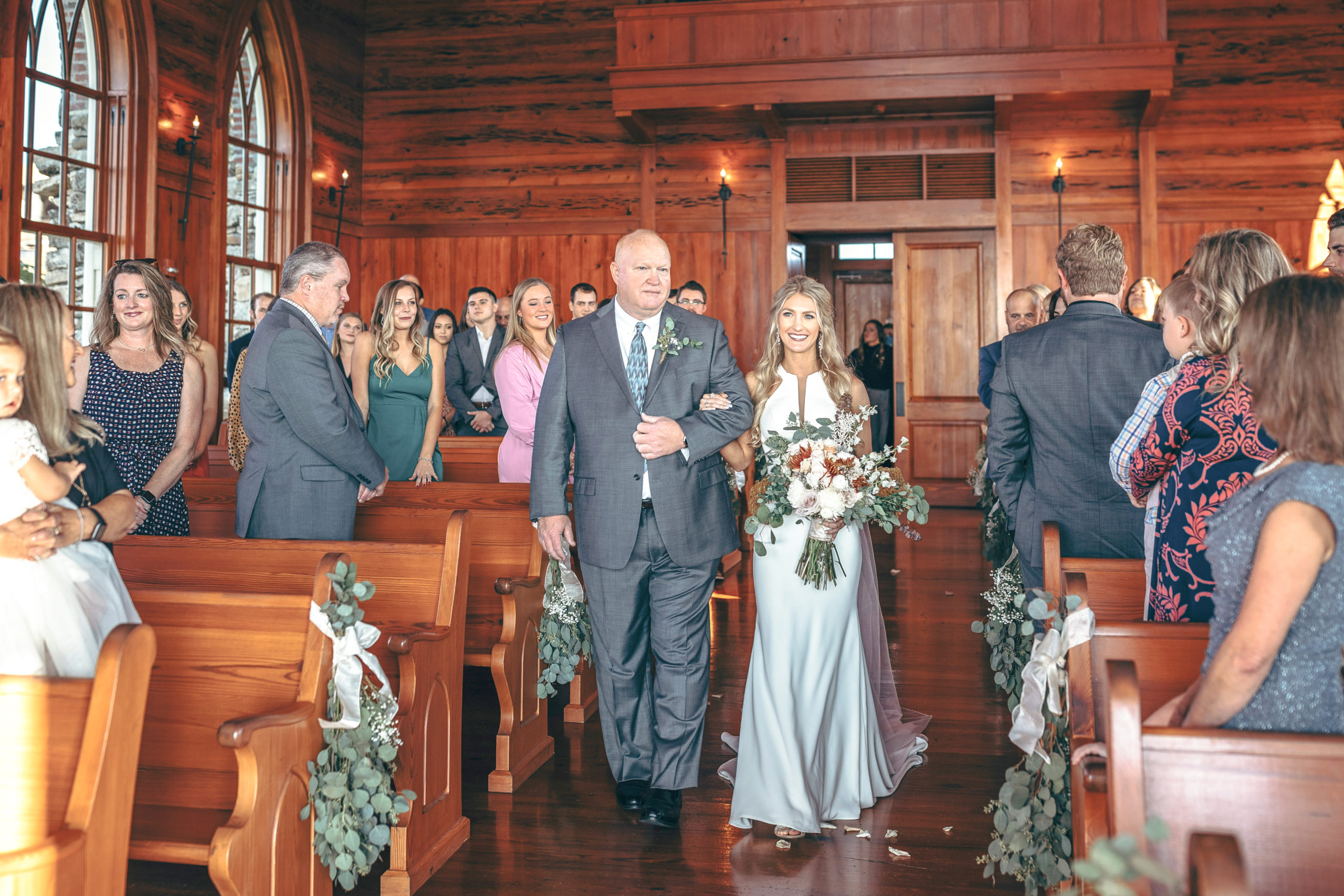 Bride walking down with her father down the isle to meet the groom at Chapel of the Ozarks at Top of the Rock wedding venue