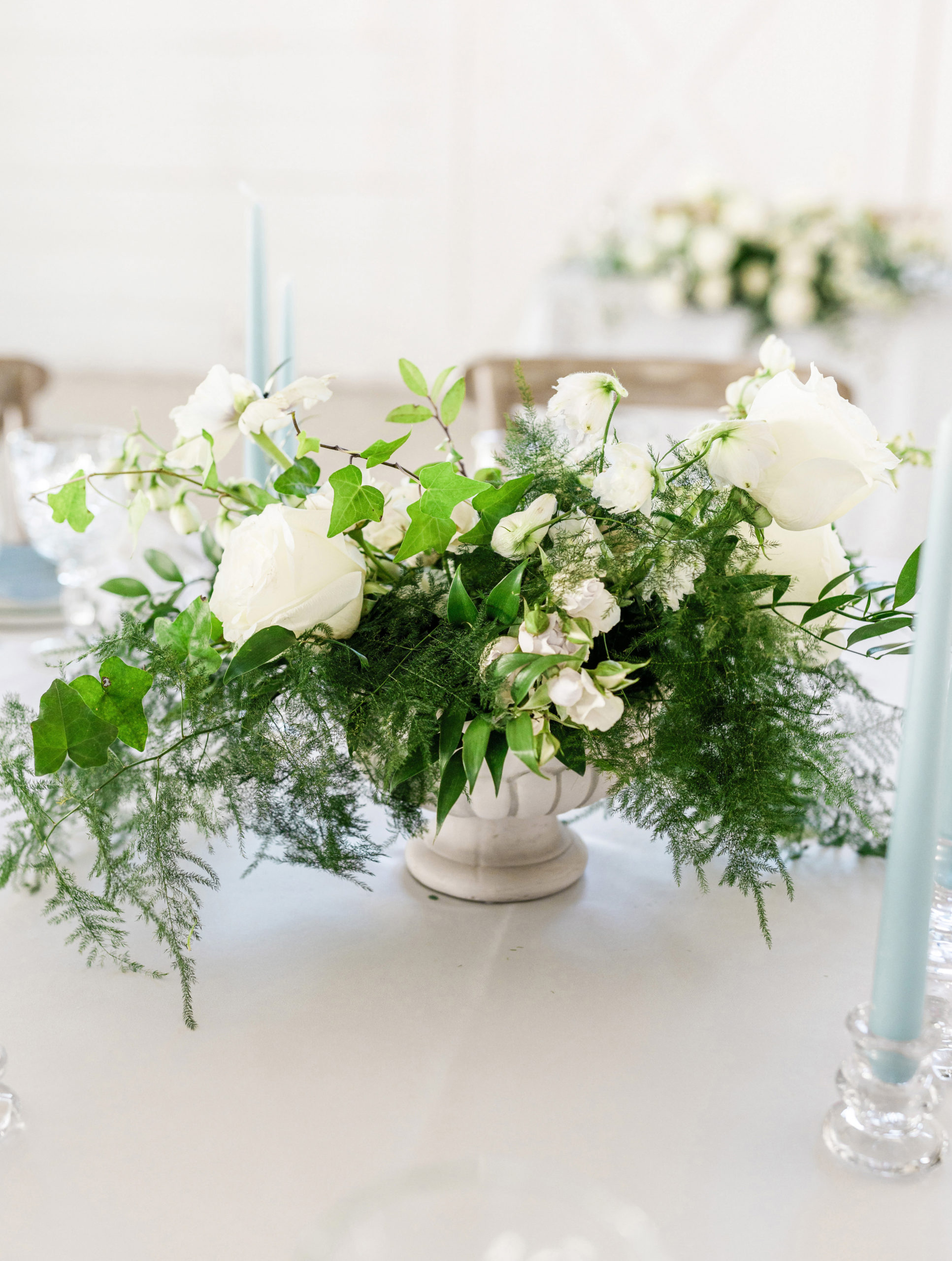 close-up shot of the beautiful white floral arrangement with light blue candles on the table, taken by Tatyana Zadorin Photography