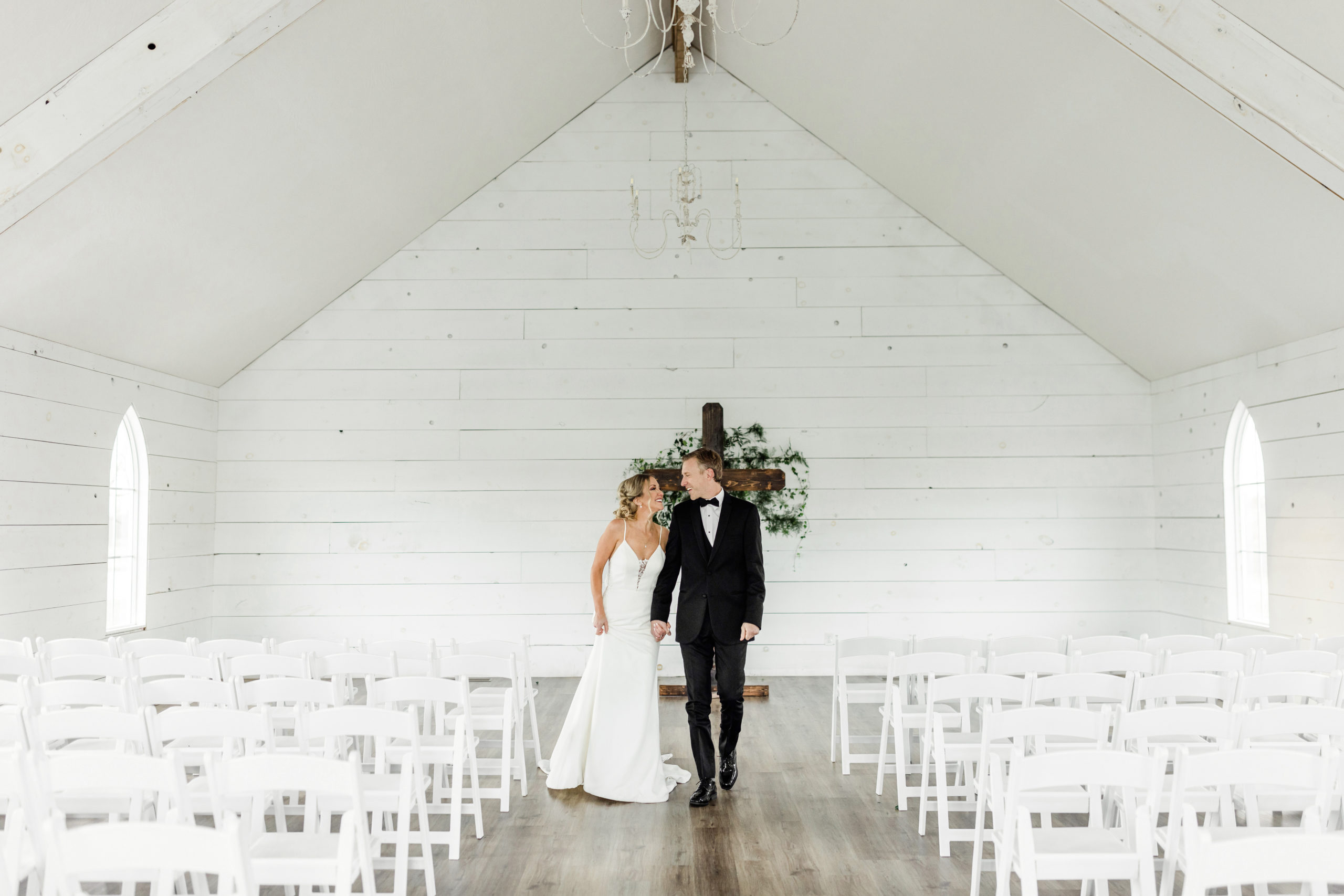 bride and groom walking together inside the sparrow lane springfield, missouri chapel portraits