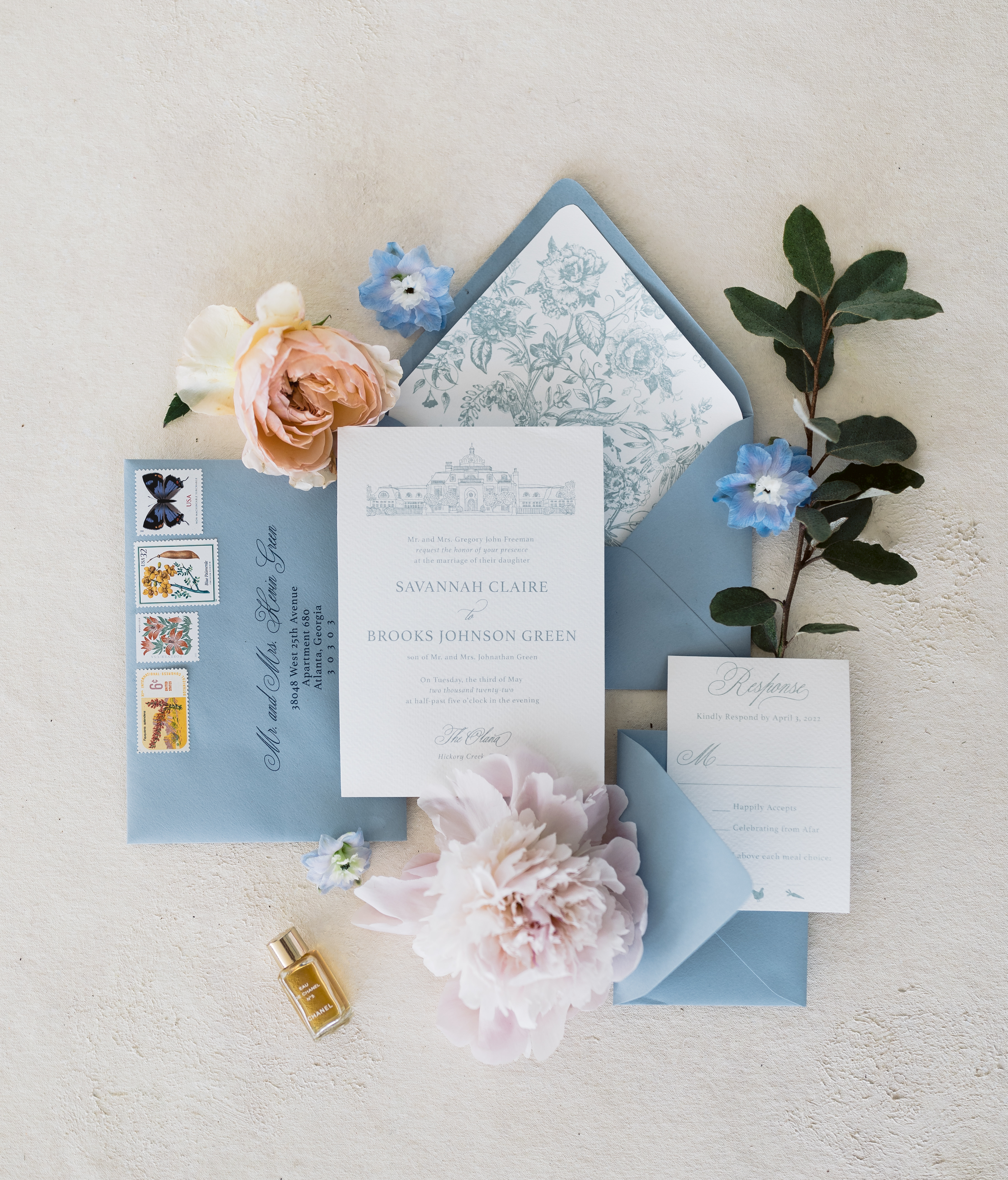 Flat-lay shot of baby blue themed wedding cards with flowers beside it, captured by Tatyana Zadorin Photography