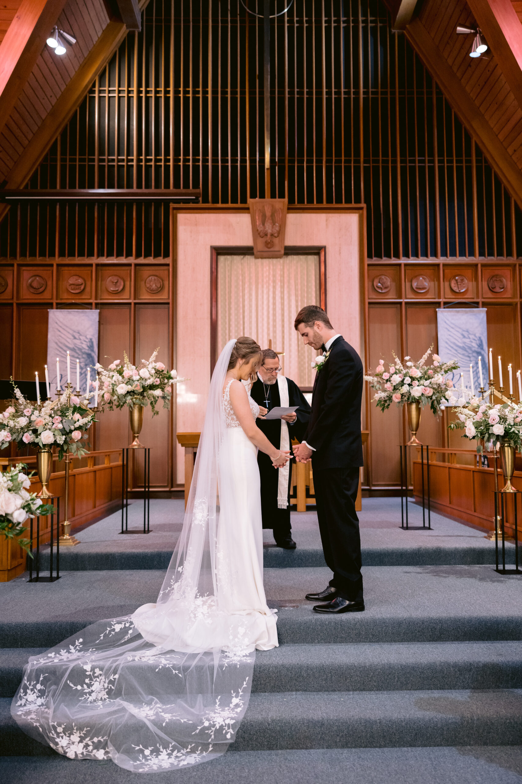 bride and groom praying at the alter at a catholic chapel