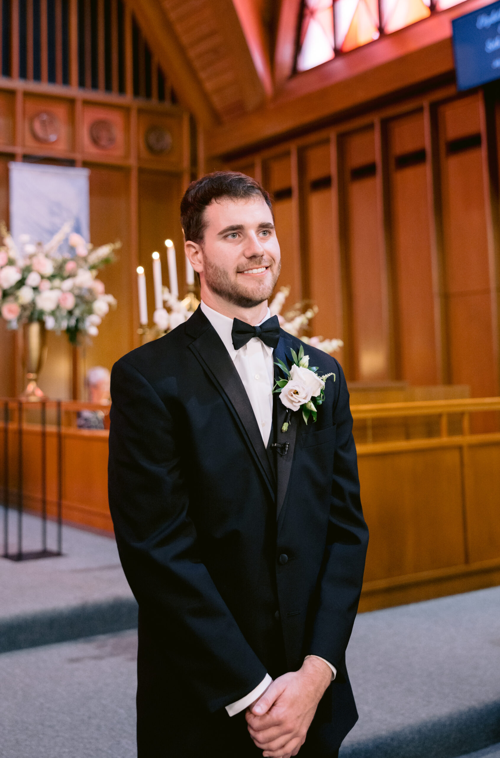 Groom looking at the bride walking down the isle inside a catholic church