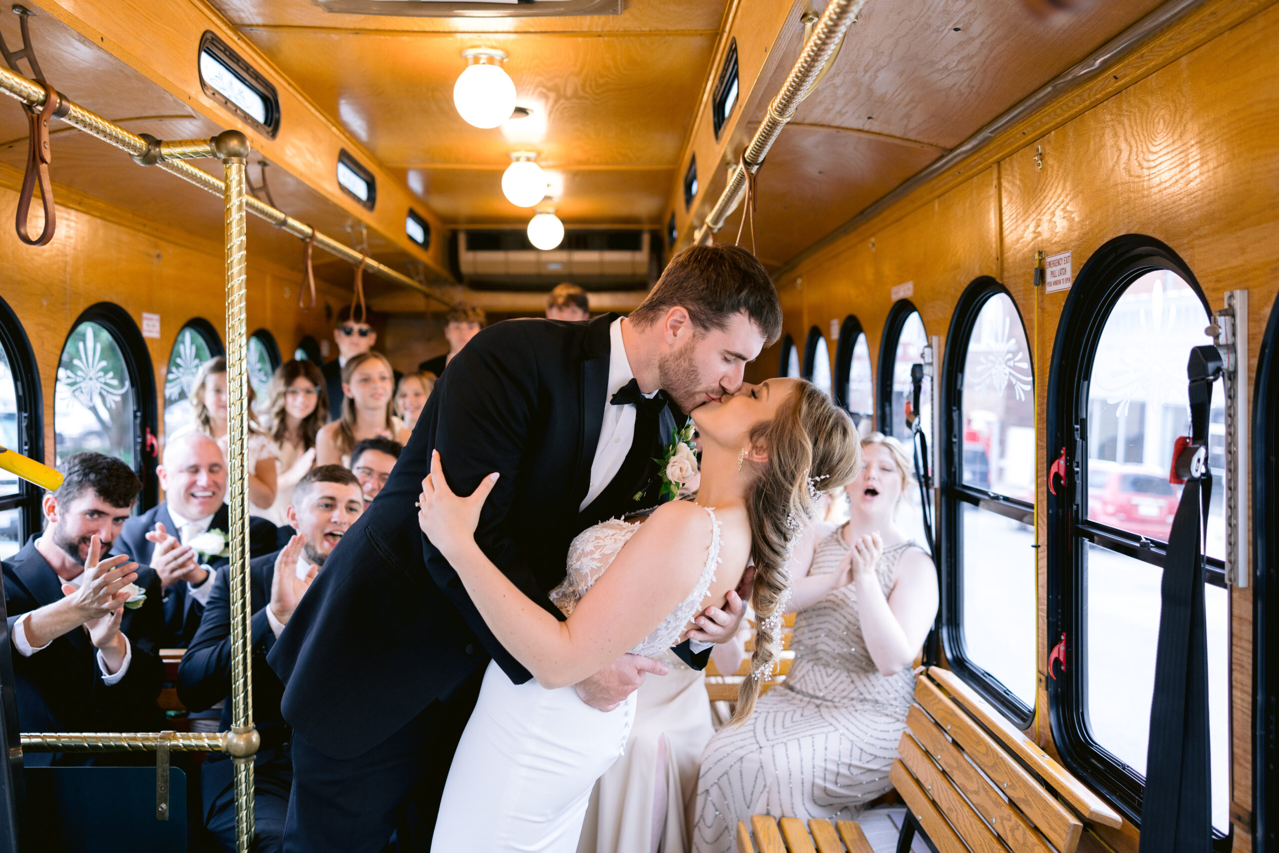 bride and groom inside the trolly with the wedding party celebrating and cheering