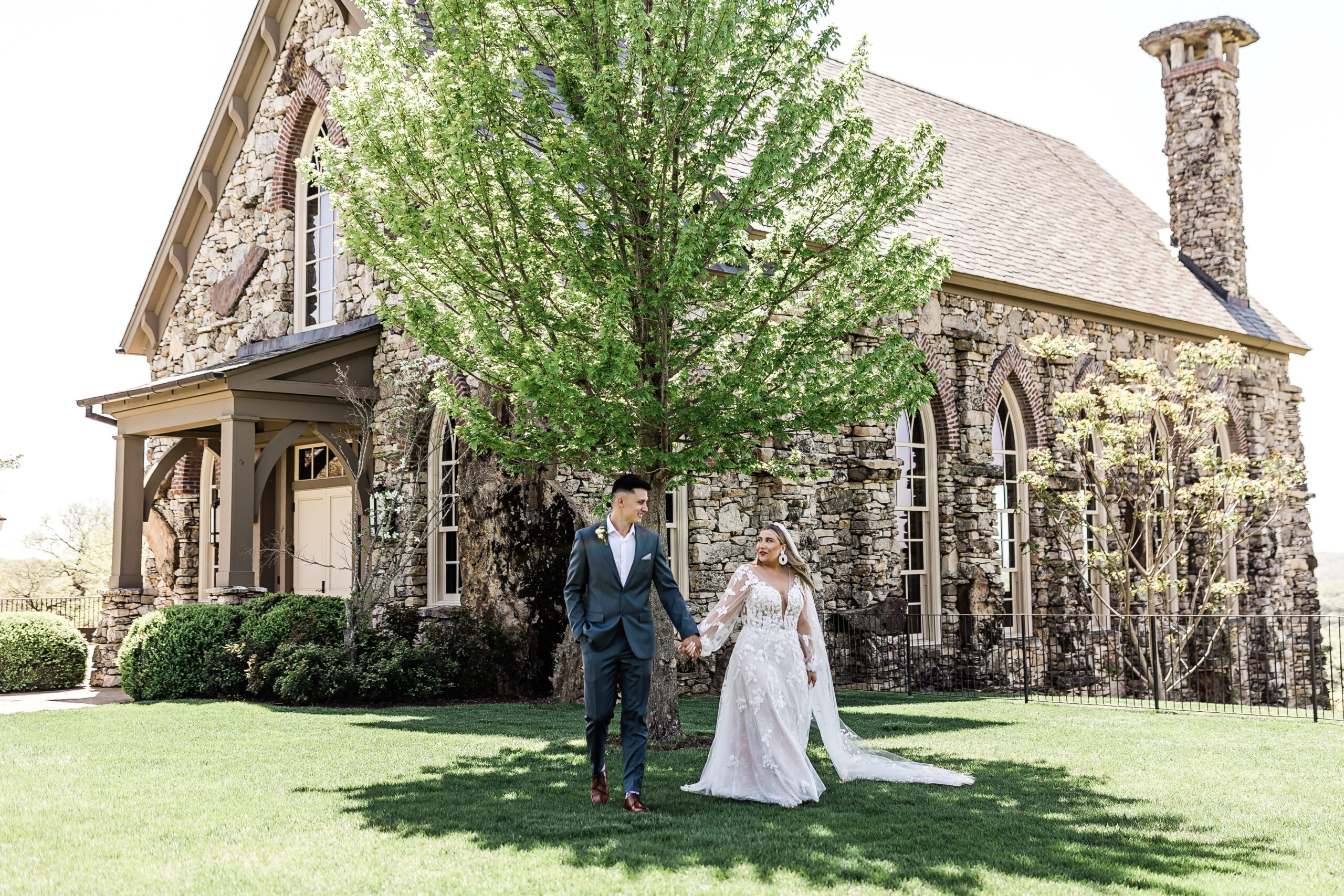 Bride and groom walking side by side in front of the Chapel of the Ozarks in Branson Missouri, Top of the Rock wedding venue