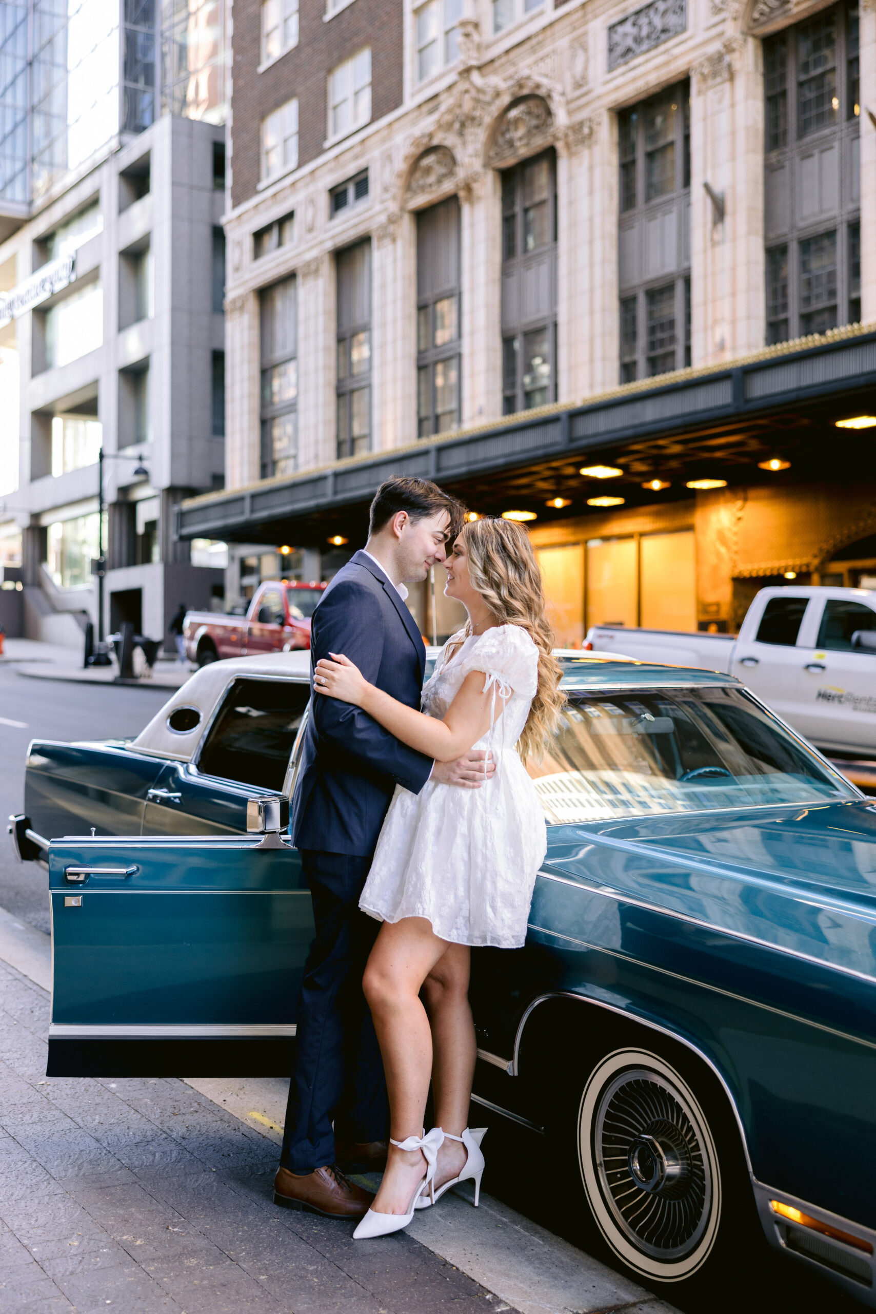 bride and groom with a vintage car, looking at each other in an intimate way