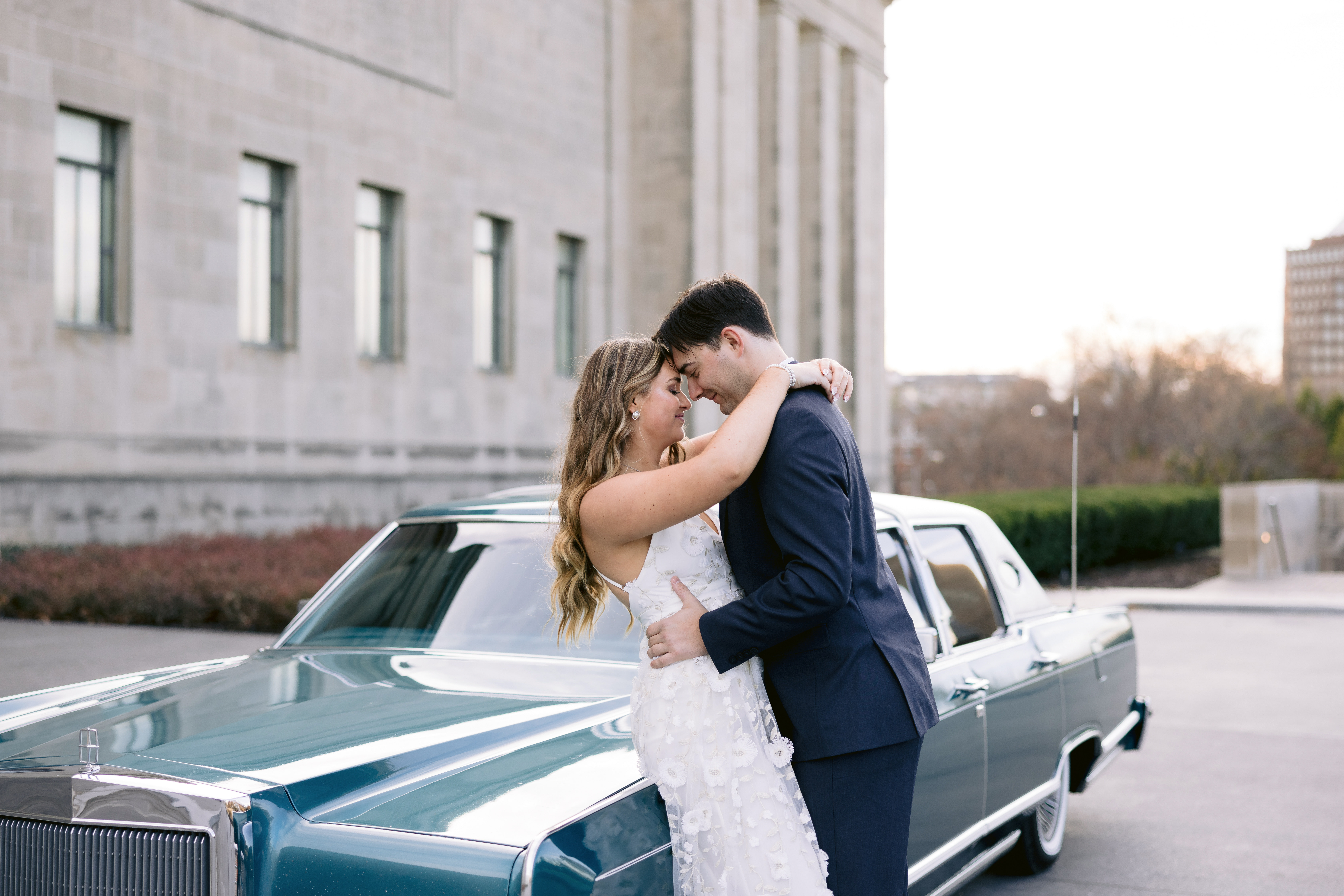 Kansas City engagement photographer. Engaged couple looking at each other next to a vintage car in MO