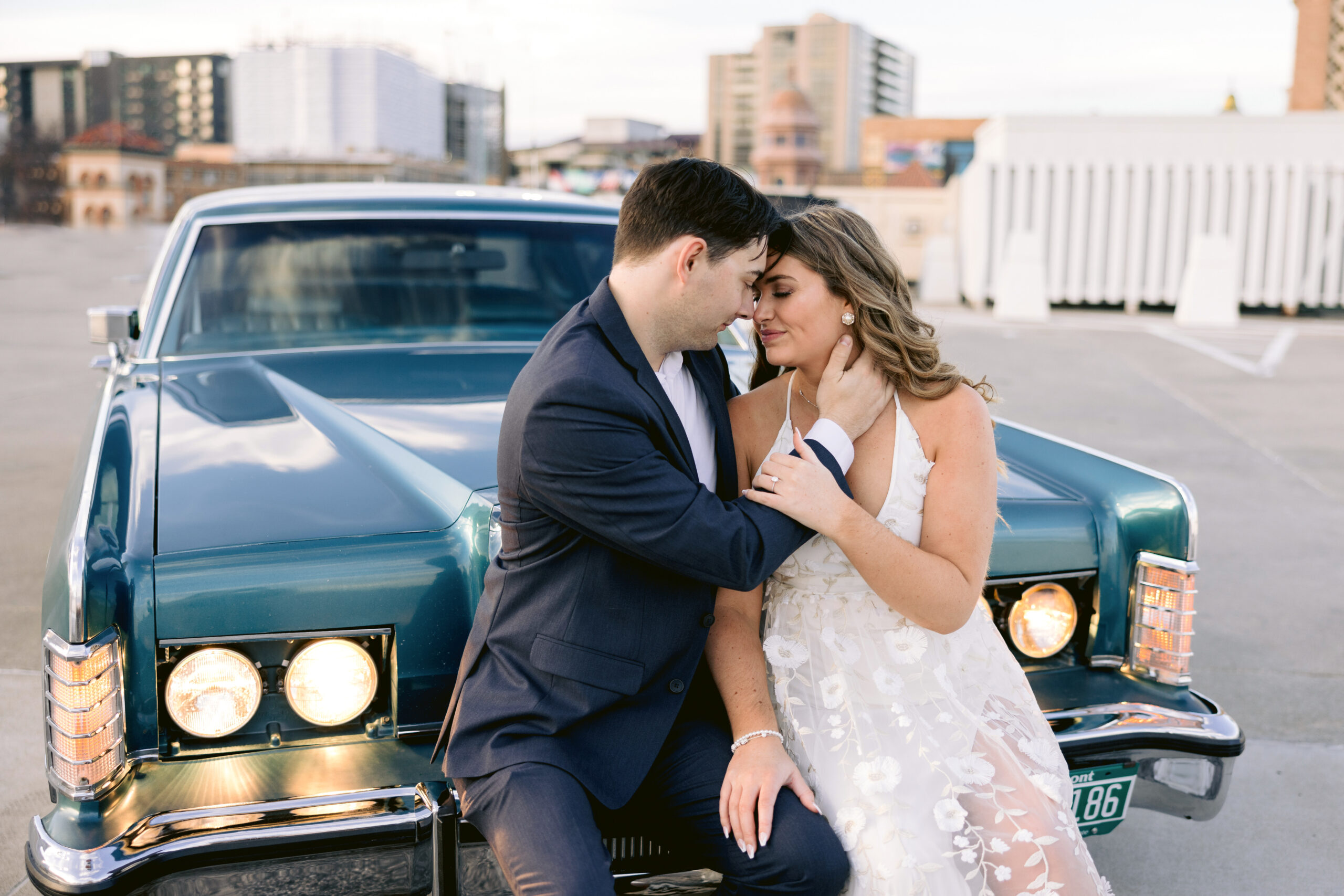 closeup of engagement couple leaning into each other sitting on a Vintage car at the Plaza in Kansas City, Missouri