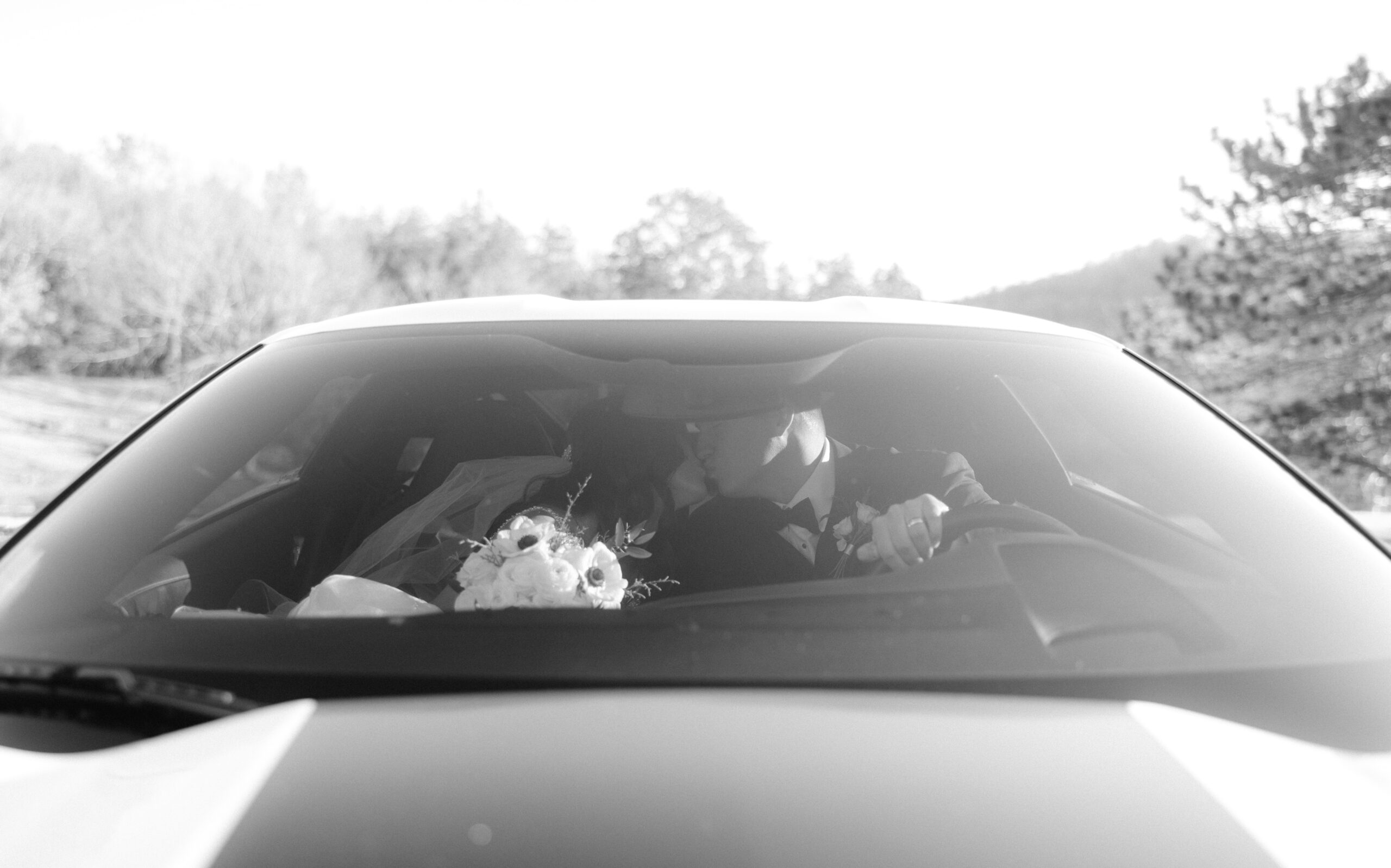 Bride and groom kissing in a vintage car