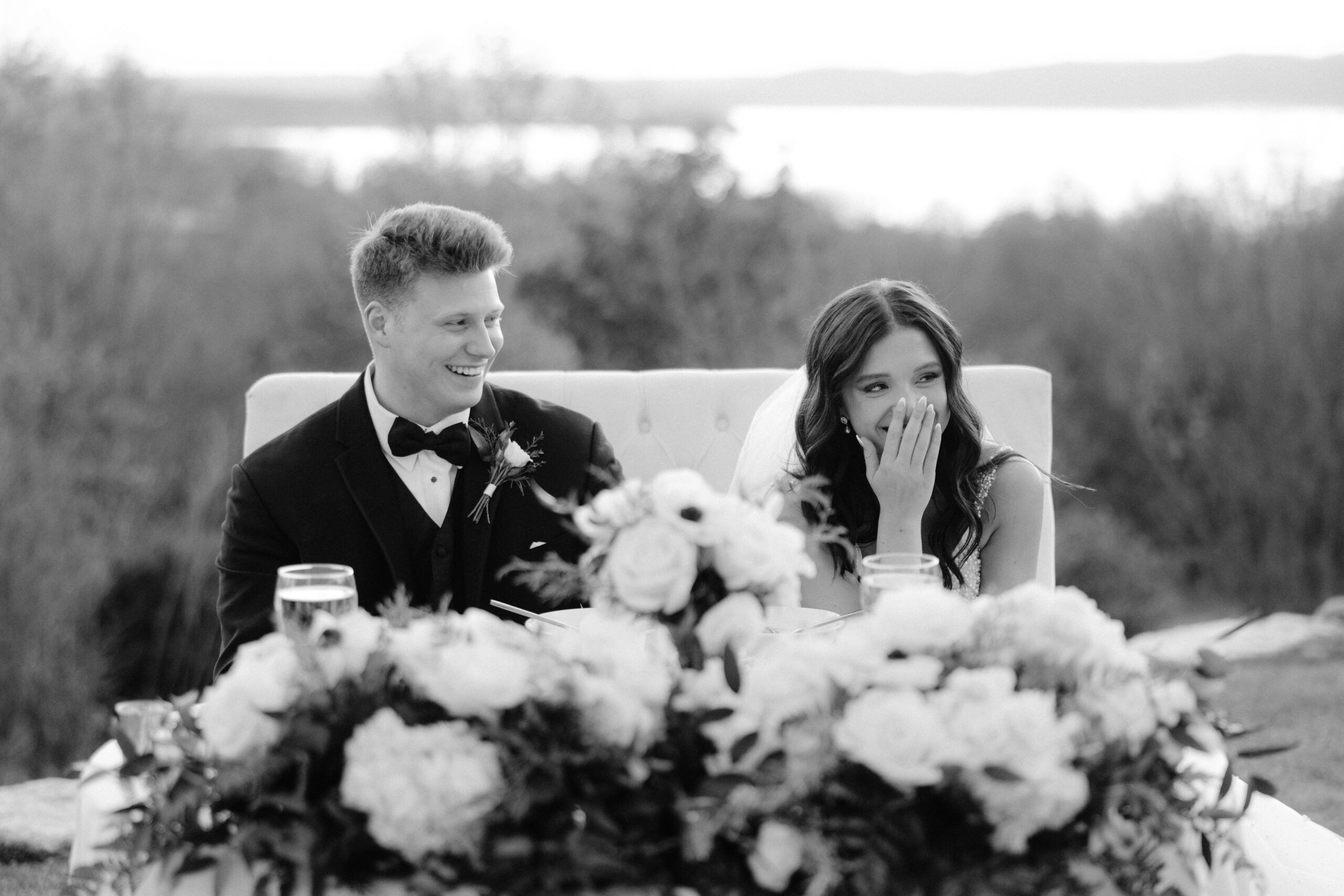 Bride and groom smiling during speeches