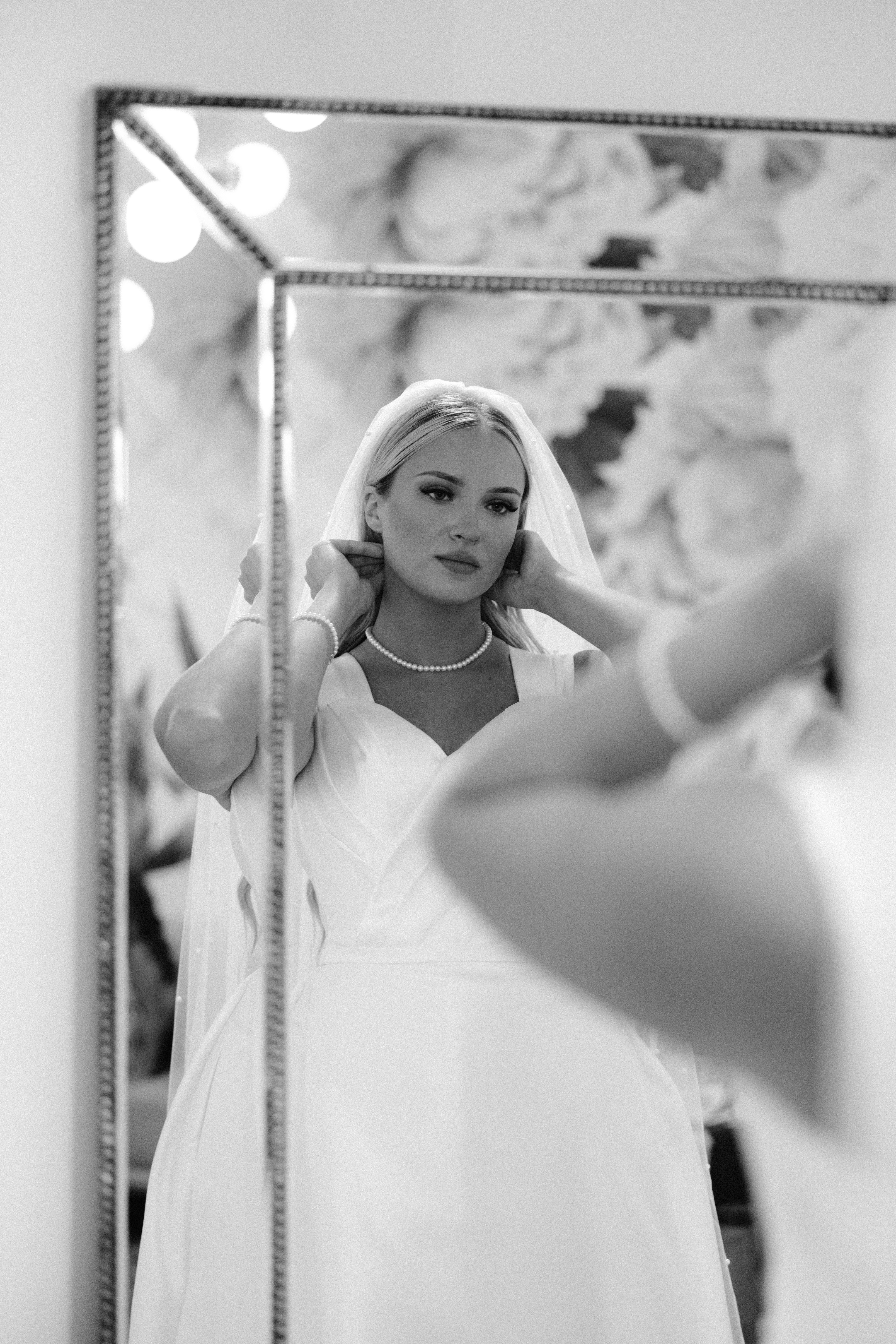 Bride getting ready and looking into the mirror portrait at the Greenhouse two rivers. Springfield Missouri wedding photographer