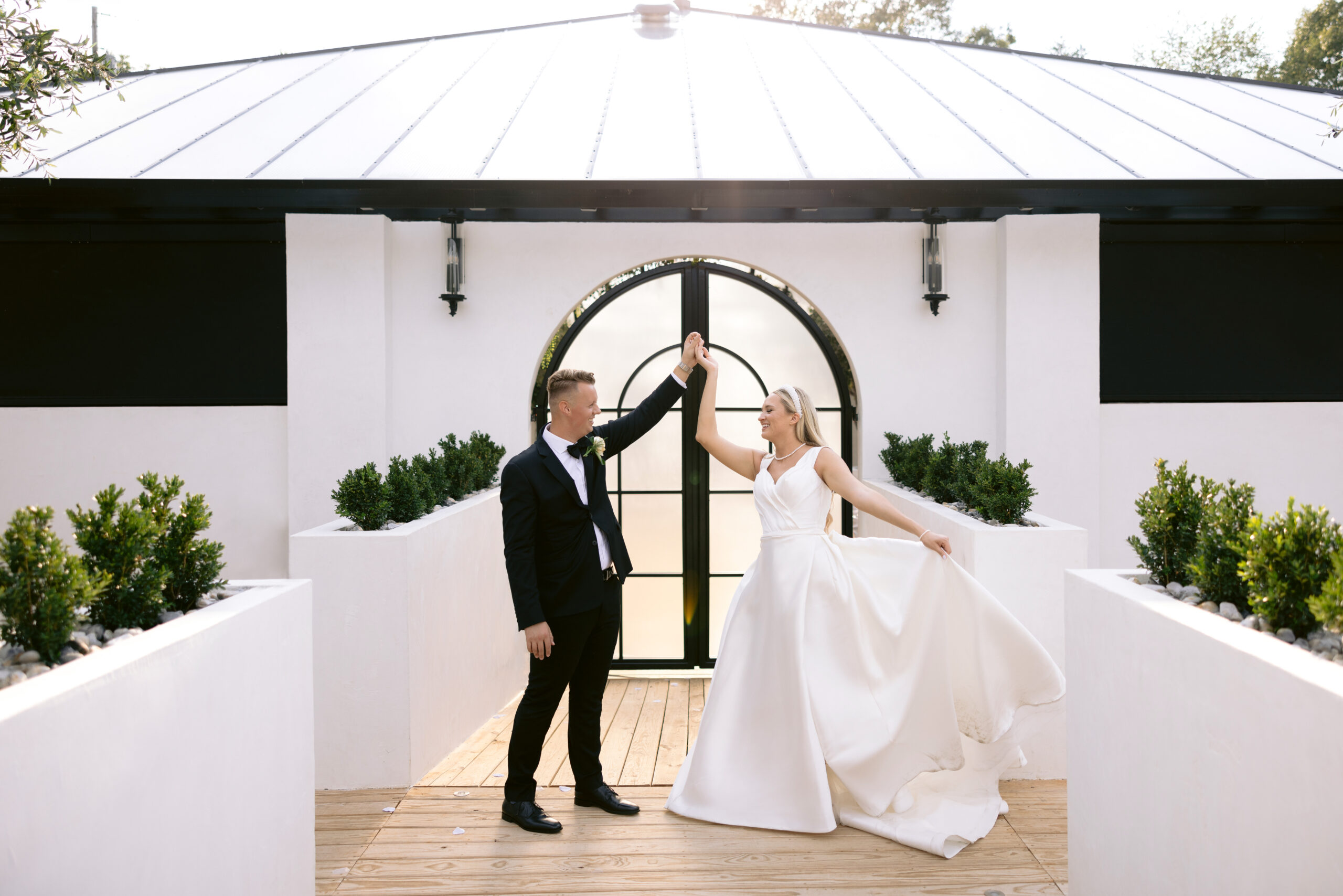 bride and groom dancing in front of the Greenhouse two rivers ceremony at golden hour. photographed by Tatyana Zadorin Photography