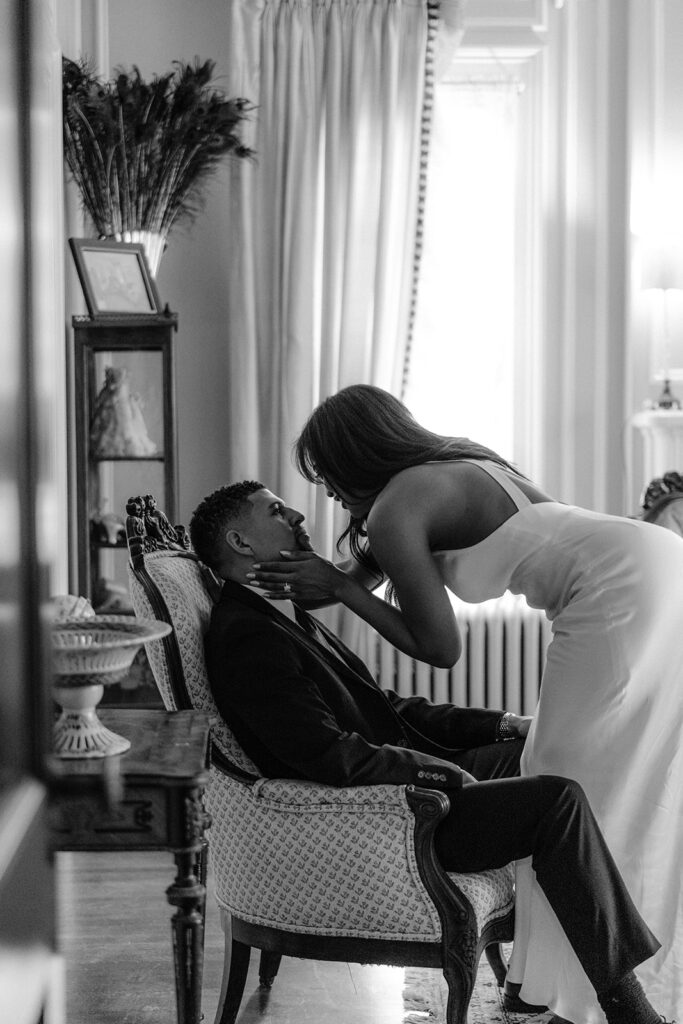 Romantic indoor engagement portrait of a couple leaning in for a kiss inside the Aldredge House in Dallas, Texas.