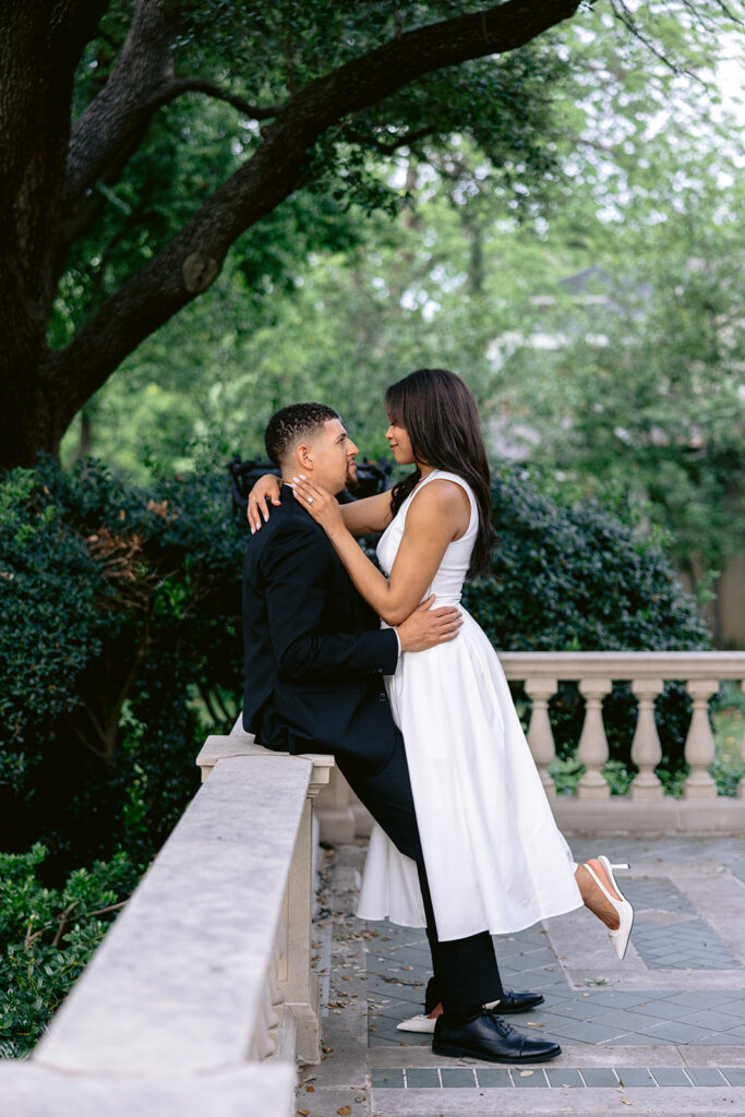 Intimate engagement photo of a couple sharing a kiss beneath the trees during a romantic Dallas engagement session.