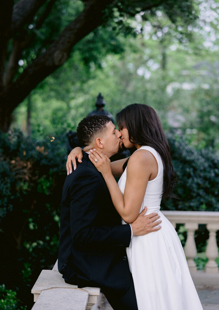 Close-up engagement portrait of a couple kissing in the gardens of the Aldredge House in Dallas, Texas.
