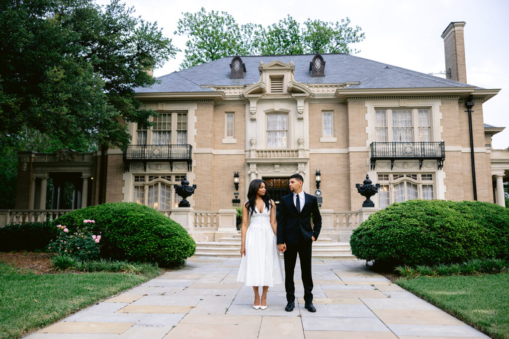 Couple walking toward the historic Aldredge House mansion during a luxury engagement session in Dallas, Texas.