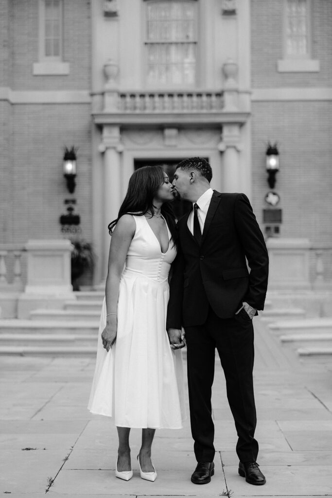 Romantic engagement photo of a couple kissing on the front steps of the Aldredge House during a Dallas engagement session.