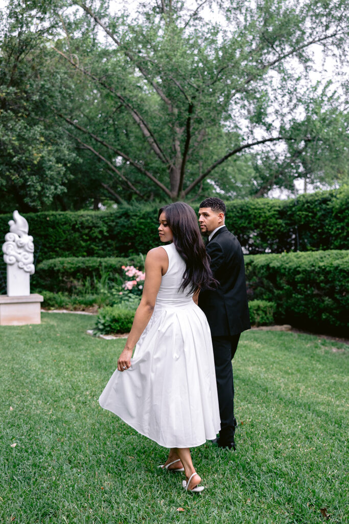 Couple dancing under oak trees during an elegant engagement session at the Aldredge House in Dallas, Texas.