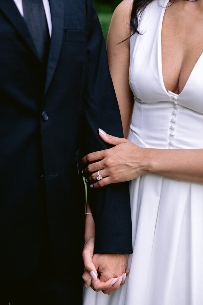 Close-up engagement photo highlighting the couple holding hands and the bride-to-be's engagement ring during their Dallas engagement session.