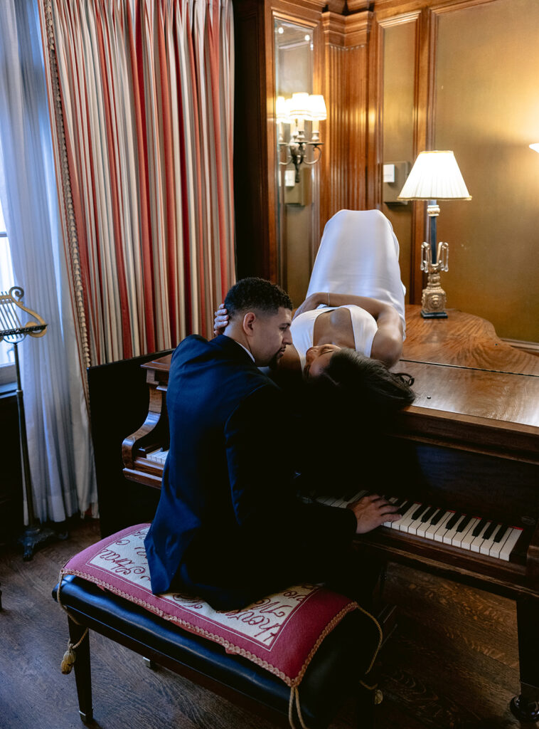 Romantic engagement portrait of a couple sharing an intimate moment beside a grand piano inside the Aldredge House in Dallas, Texas.