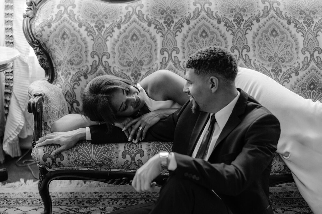 Luxury engagement portrait of a couple relaxing together inside the historic Aldredge House with elegant vintage décor.