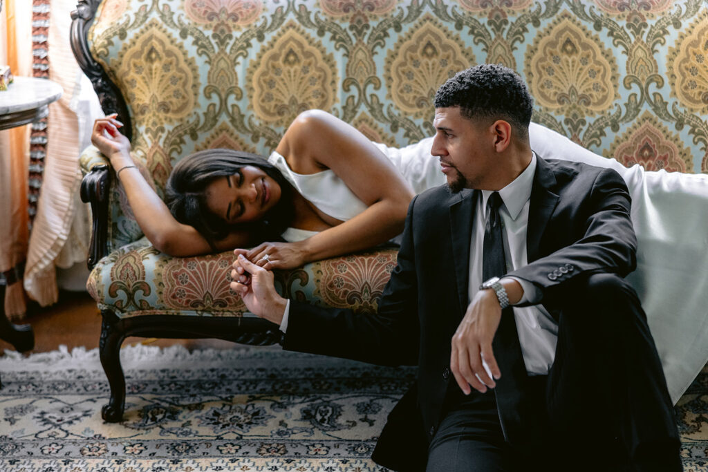 Editorial engagement portrait of a couple inside the Aldredge House featuring timeless architecture, antique furnishings, and romantic natural light.