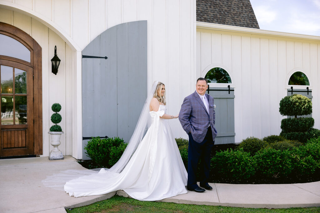 Emotional first look between the bride and her father, capturing heartfelt reactions, joyful smiles, and candid moments outside The French Farmhouse wedding venue in Collinsville, Texas before the wedding ceremony.