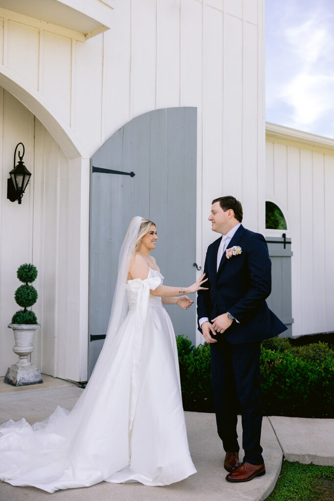 Romantic bride and groom first look filled with joyful smiles, emotional reactions, warm embraces, and intimate wedding portraits outside The French Farmhouse wedding venue in Collinsville, Texas before the ceremony.