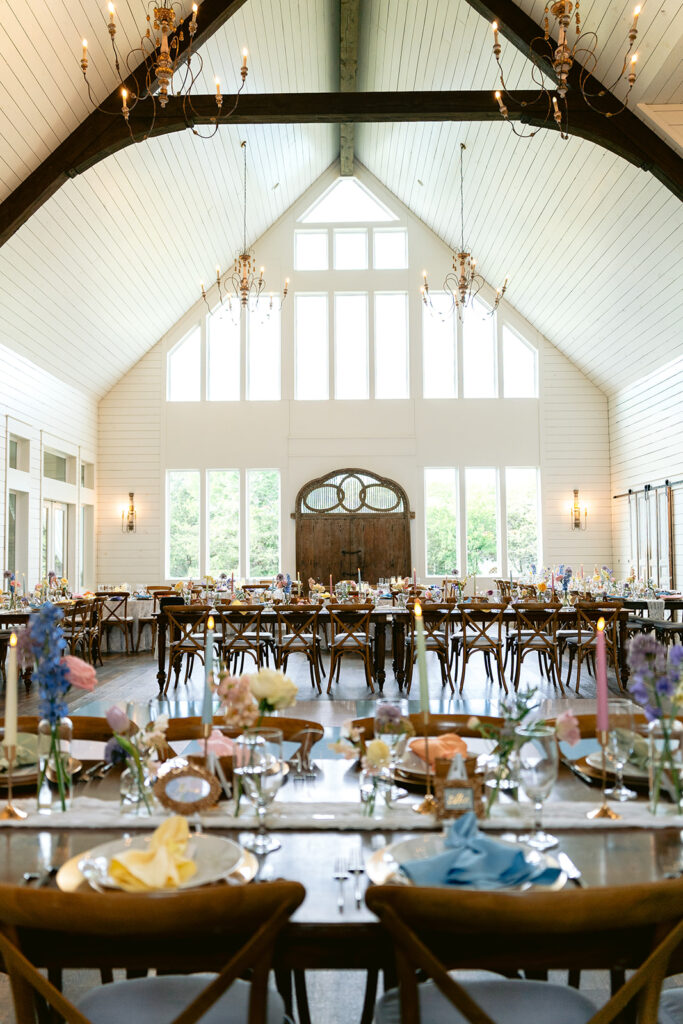 Elegant wedding reception details featuring a floral wedding cake, reception tablescape, custom seating chart, outdoor fountain, and timeless décor at The French Farmhouse wedding venue in Collinsville, Texas.