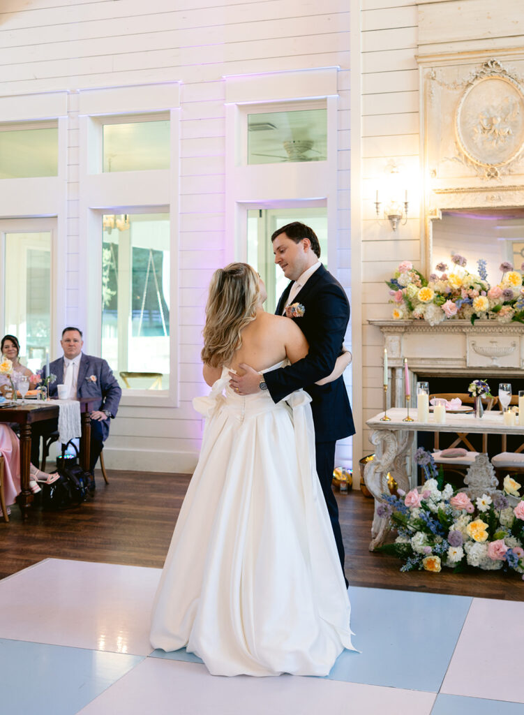 Romantic first dance during the wedding reception featuring the bride and groom sharing an intimate dance, emotional moments, and heartfelt reactions from family and guests at The French Farmhouse wedding venue in Collinsville, Texas.
