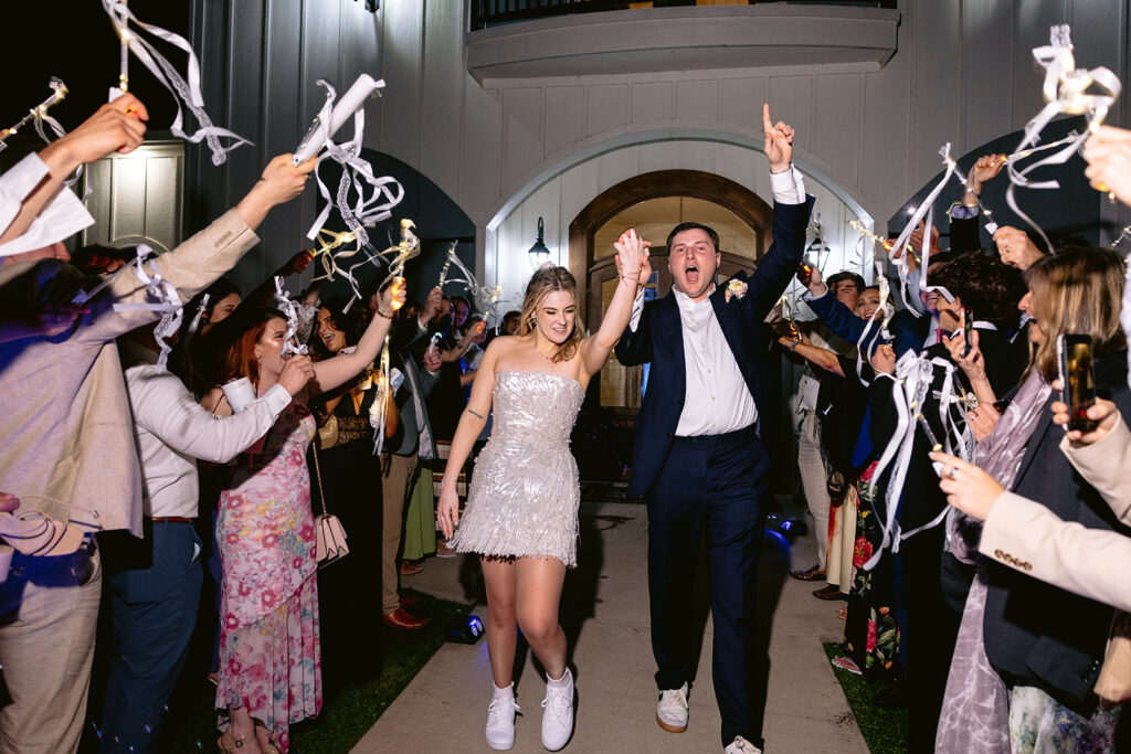 Romantic wedding reception finale featuring the bride and groom sharing their last dance, joyful celebration, and a festive ribbon wand exit surrounded by family and friends at The French Farmhouse wedding venue in Collinsville, Texas.